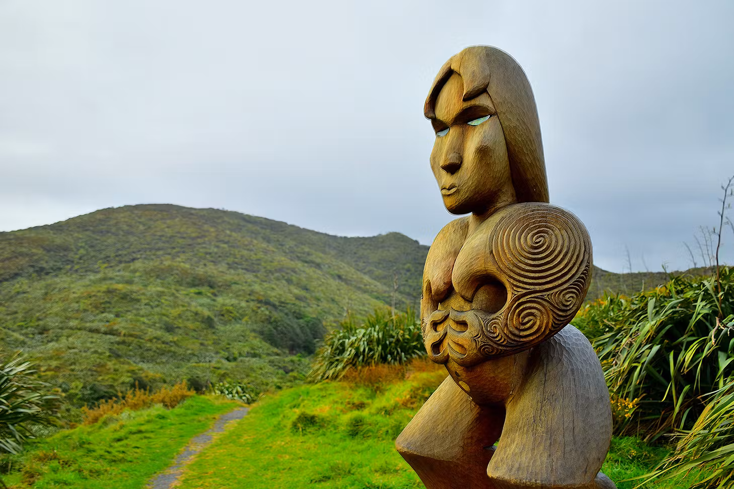 Wooden Maori carving of Hinerangi, female ancestor guardian figure at Piha, New Zealand.